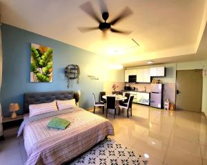 a bedroom with a bed and a table and a kitchen at Bali Residence Impian Raudah in Melaka