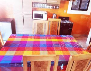 Eine Küche mit einem Tisch mit einer bunten Tischdecke in der Unterkunft Azomalli in Tepoztlán