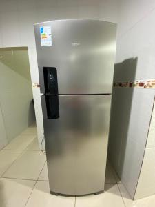 a stainless steel refrigerator sitting in a kitchen at Casa aconchegante próximo ao SESC Bertioga/SP. in Bertioga