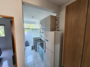 eine Küche mit einem weißen Kühlschrank und einem Herd in der Unterkunft Residêncial Maria de Castro in Mairiporã + 4 Fotos