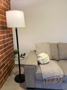 Una sala de estar con un sofá y una lámpara. en Acogedor apartmanto en el corazón de zona 10, en Estación Pamplona