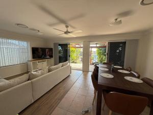 a living room with a long couch and a table at Pet Friendly - Plunge Pool Canal Sunset View - Private Jetty in Bongaree