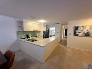 a kitchen with a counter top in a room at Pet Friendly - Plunge Pool Canal Sunset View - Private Jetty in Bongaree