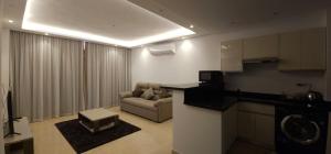 Una sala de estar con un sofá y un televisor en una habitación. en Elhambra First Avenue, en Hurghada