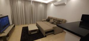 Una sala de estar con un sofá y un televisor de pantalla plana. en Elhambra First Avenue, en Hurghada
