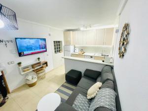 a living room with a couch and a tv at Pretty Bungalow Apartments in Polop