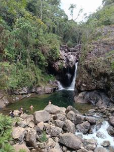 a group of people swimming in a river with a waterfall at pousada Montanhez ap3 in Alto Caparao +18 photos
