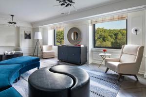 a living room with a blue bed and a chair at JW Marriott Essex House New York in New York