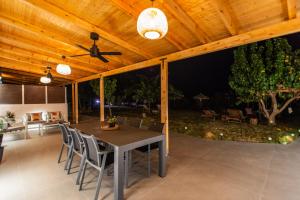 a patio with a table and chairs under a wooden ceiling at YOLO Resort- Giardino in Alykes