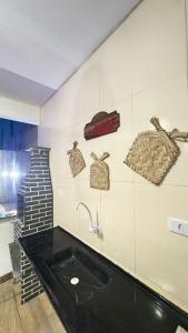 a kitchen with a black counter and a sink at Recanto dourado Suíte 5 in São Miguel dos Milagres