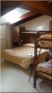 オヴィンドリにあるAlbergo Il Cacciatoreの二段ベッド2台とベッド1台が備わる客室です。