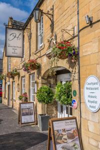 ein Gebäude mit Topfpflanzen nebeneinander in der Unterkunft The White Hart Royal, Moreton-in-Marsh, Cotswolds in Moreton-in-Marsh