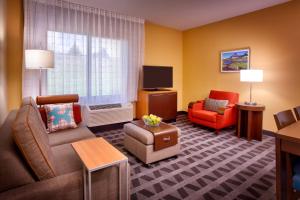 a living room with a couch chair and a tv at TownePlace Suites by Marriott Missoula in Missoula