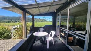 WaikakahoにあるTiny Home Container house Above the Vinesのバルコニー(テーブル、椅子付)