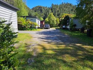 a street with a car parked on the side of a house at Queenstown Copper Country Cabins in Queenstown +8 photos