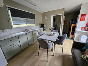a kitchen with a table and chairs in a room at Queenstown Copper Country Cabins in Queenstown