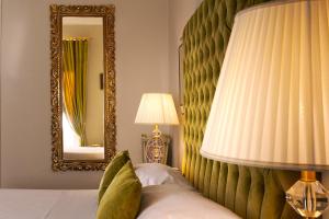 a bedroom with a bed with a mirror and a lamp at B&B Palazzo Cerami in Catania