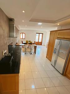 - une cuisine avec des comptoirs noirs et un réfrigérateur dans l'établissement Spacious 4-Bedroom Apartment with Sea View, à San Ġiljan
