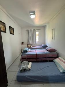 a bedroom with two beds and a window at Casa em Condomínio - Salinópolis in Salinópolis +29 photos
