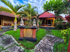 a garden with a fountain in front of a house at Wadon Menjangan homestay in Banyuwedang +35 photos