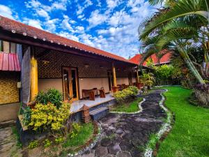 a house with a patio and a grass yard at Wadon Menjangan homestay in Banyuwedang