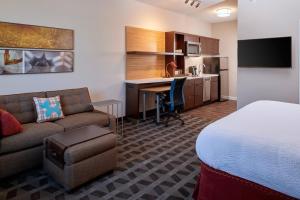 SolonにあるTownePlace Suites by Marriott Cleveland Solonのベッド、デスク、ソファが備わるホテルルームです。