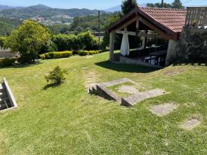 a garden with a table and a bench in the grass at Quinta do Eirô in Fonte Arcada