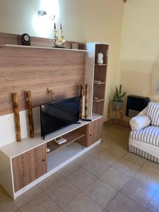 een woonkamer met een entertainmentcentrum met een flatscreen-tv bij Lugar para Relajarse in Duggan +13 foto's
