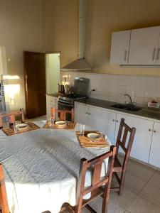 een keuken met een tafel met 2 stoelen en een keuken met bij Lugar para Relajarse in Duggan