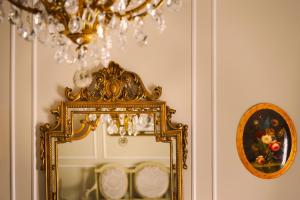 a mirror on a wall next to a chandelier at B&B Palazzo Cerami in Catania