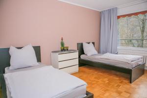 a bedroom with two beds and a window at GMA Apartment B16 in Lahr