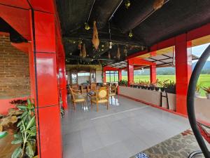 a dining room with red walls and a table and chairs at Penginapan Syariah Bunga Sonsang in Sungaidaras