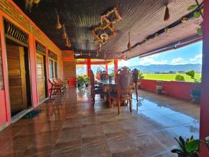 a porch with chairs and a table with a view at Penginapan Syariah Bunga Sonsang in Sungaidaras +24 photos