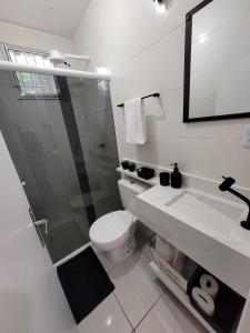 Un baño con ducha, inodoro y lavabo. en Estrela do Mar Studio, en Itapema
