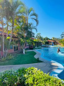 a pool at a resort with palm trees and a person swimming at Cómodo town-house con piscina in El Marite +26 photos