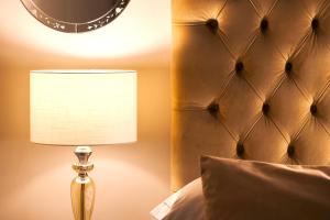a lamp sitting next to a bed with a headboard at B&B Palazzo Cerami in Catania