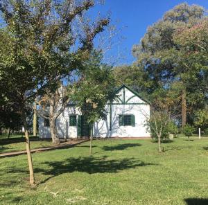 a white house in the middle of a yard at Finca Santo Pietro in T. Yofré