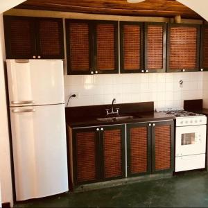 a kitchen with a white refrigerator and a sink at Finca Santo Pietro in Tomás Jofré