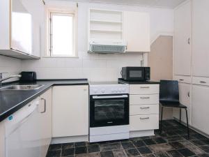 a white kitchen with a stove and a sink at Holiday home in Denmark in Ringkøbing +28 photos