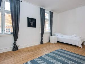 a white room with a bed and two windows at Holiday home in Denmark in Ringkøbing
