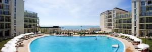 a large swimming pool with chairs and umbrellas at Private Studio 1st line in Pomorie