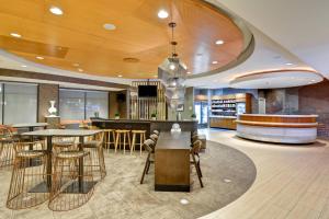 a lobby with tables and chairs and a bar at SpringHill Suites Cincinnati Airport South in Florence