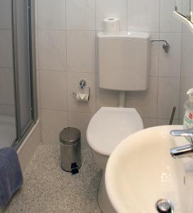 Łazienka z białą toaletą i umywalką w obiekcie Weinstube Schwarzamsel w mieście Spira