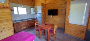 a kitchen with a wooden table and a kitchen with a sink at Depto Castillo in El Bolsón