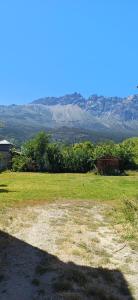 un campo d'erba con le montagne sullo sfondo di Depto Castillo a El Bolsón