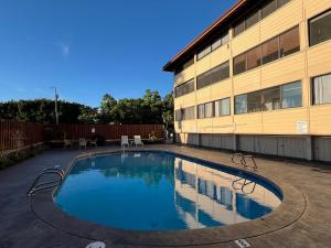 a swimming pool in front of a building at Holualoa Gardens 303 in Kailua-Kona