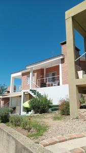 een groot bakstenen gebouw met een balkon bij Cabañas Casitas De Emma in Villa Carlos Paz
