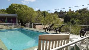een zwembad met twee stoelen naast een hek bij Cabañas Casitas De Emma in Villa Carlos Paz +46 foto's