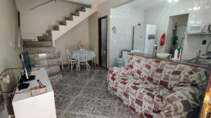 a living room with a couch and a staircase at Casa em Arraial do Cabo in Arraial do Cabo