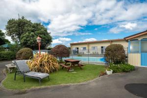 einen Hof mit einer Bank, einem Picknicktisch und einem Gebäude in der Unterkunft Spanish Lady Motel in Napier